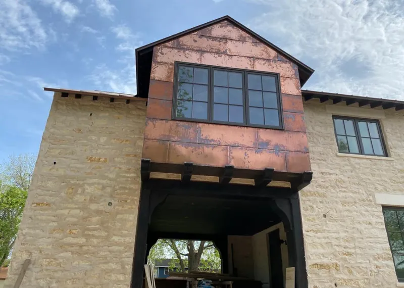 Copper metal panel facade on a stone building for Roof Repair in Fort Scott